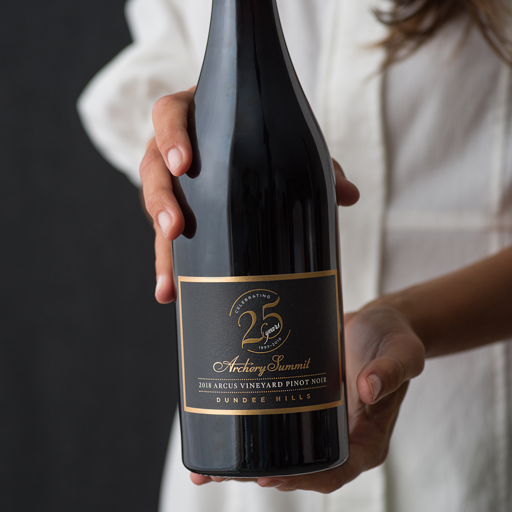 Woman holding bottle of 25th Anniversary Dundee Hills Pinot Noir