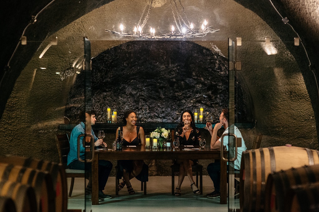 Four People Wine Tasting In Cave