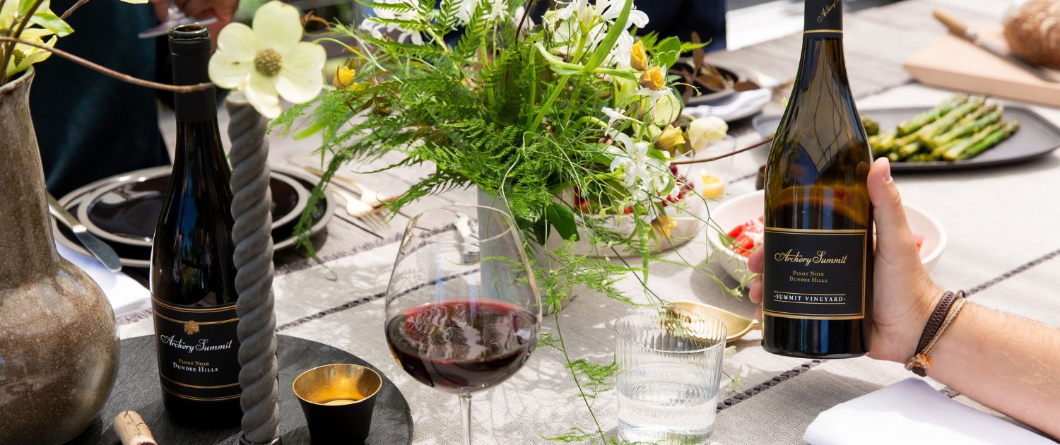 Photo of Summit Vineyard wine bottle in front of a beautiful spring picnic table.