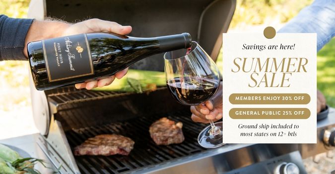 A person pours red wine into a glass near a grill with steaks cooking. A sign advertises a summer sale featuring member and public discounts, plus shipping offers—perfect for those looking to buy wine for their next gathering.