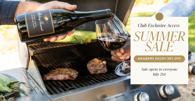 A person pours red wine into a glass beside a grill with steaks cooking. A sign reads: Club Exclusive Access SUMMER SALE, MEMBERS ENJOY 30% OFF—buy wine now and savor the savings before the sale opens to everyone July 21st.